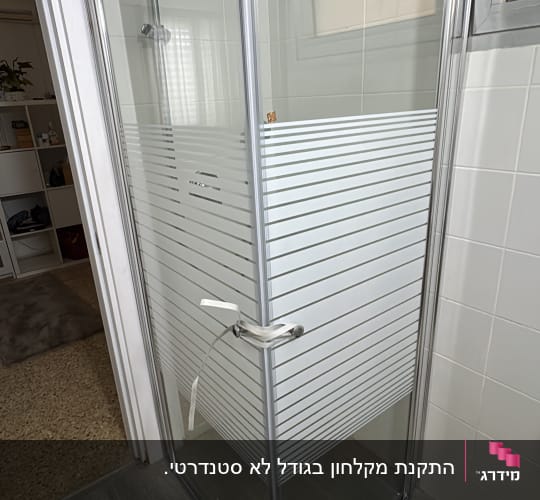 מקלחון זכוכית פינתי עם דוגמת פסים לאחר התקנה בחדר רחצה